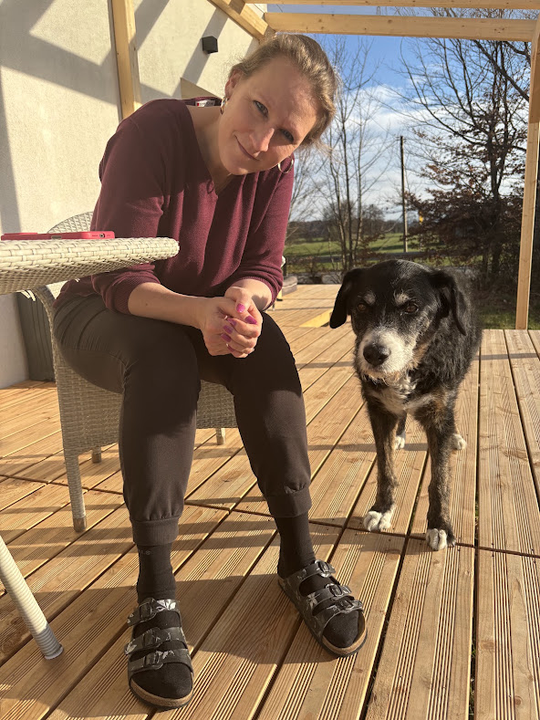 Hundebesitzerin mit ihrem Hund auf der Terrasse eines Hauses im 5-Seen-Land