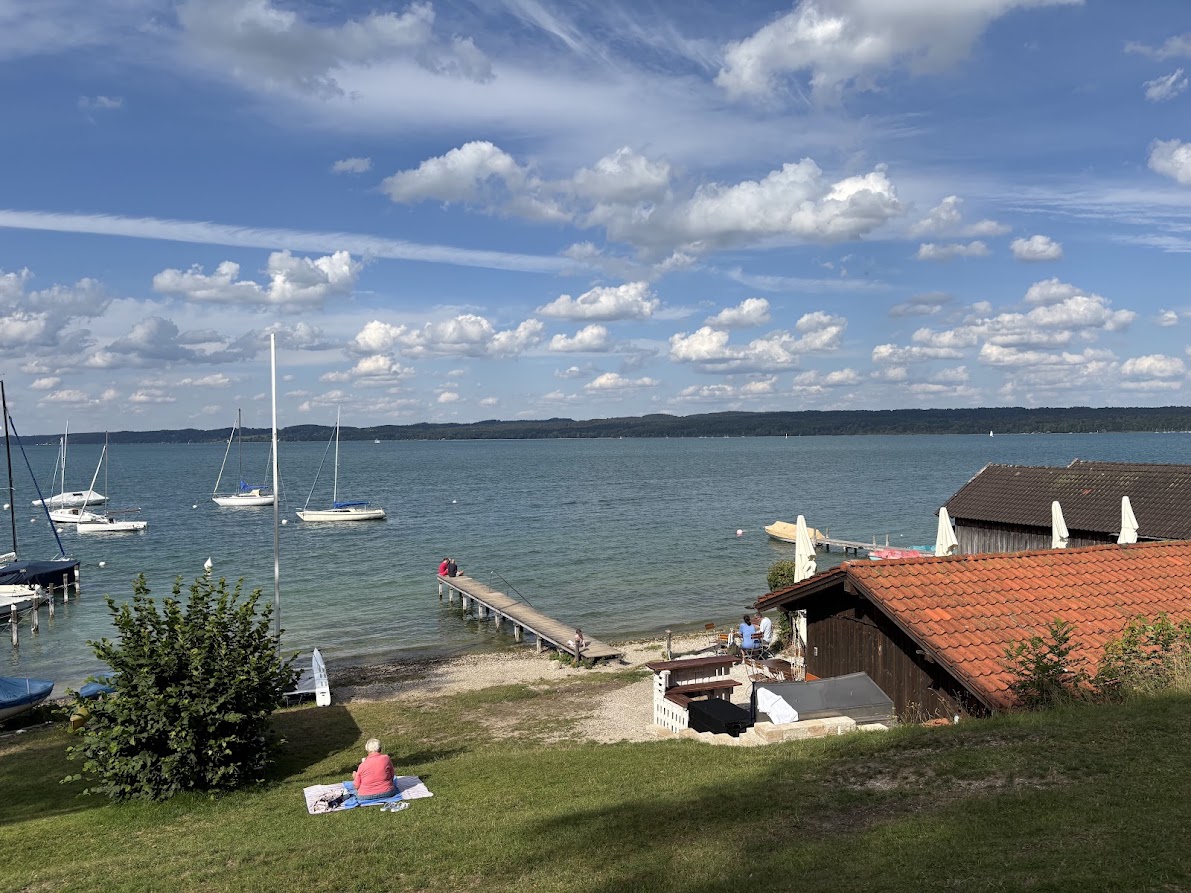 Ruhiges Südufer mit Steg, Bootshaus und ankernden Segelbooten