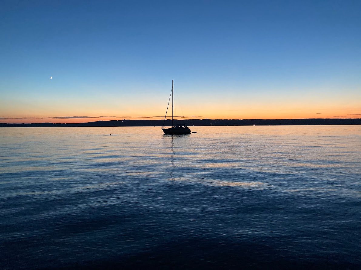 Segelboot in der Dämmerung mit Mondsichel am Starnberger See